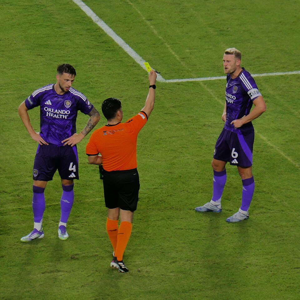 Árbitro mostrando tarjeta amarilla en partido argentino